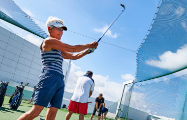 A women swinging her golf club on the golf course at Club La Santa Lanzarote.