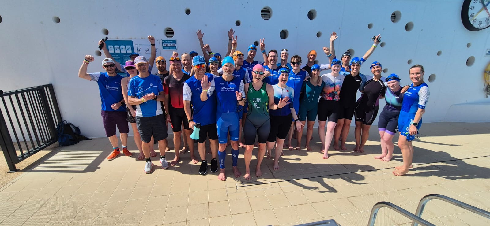 The triathlon camp group posing together and waving at the camera